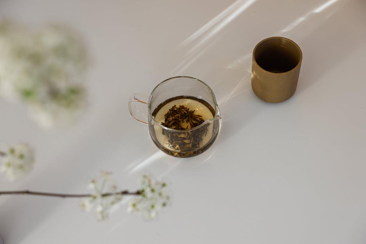 Glass cup of herbal tea and flowers in a serene minimalist setting